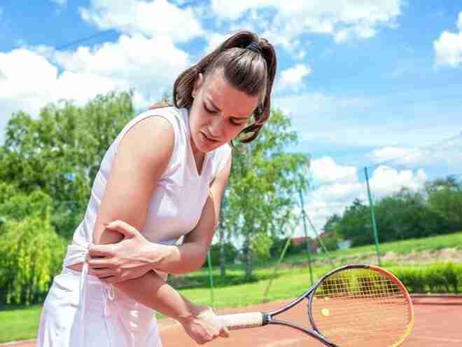 Woman playing tennis with tennis elbow