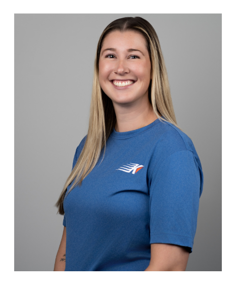 Ashlie Artz - young woman wearing a blue Kinetic Physical Therapy tshirt